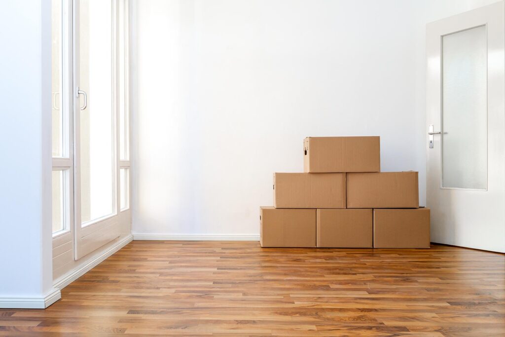 Moving, Boxes, In ,An ,Empty, Apartment, Against ,A, White, Wall
